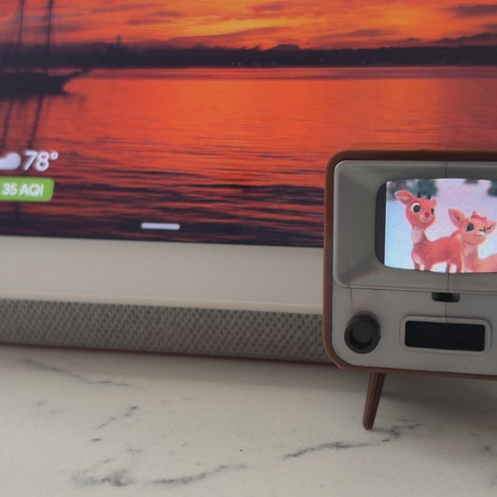 Tiny TV 2 playing the Rudolph Christmas cartoon with a smart speaker in the background for size comparison. 