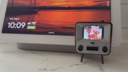 Tiny TV 2 playing the Rudolph Christmas cartoon with a smart speaker in the background for size comparison. 