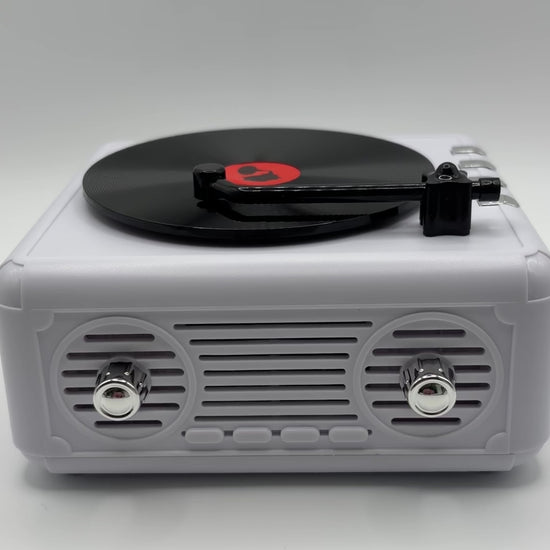 a white retro vinyl record player bluetooth speaker playing music