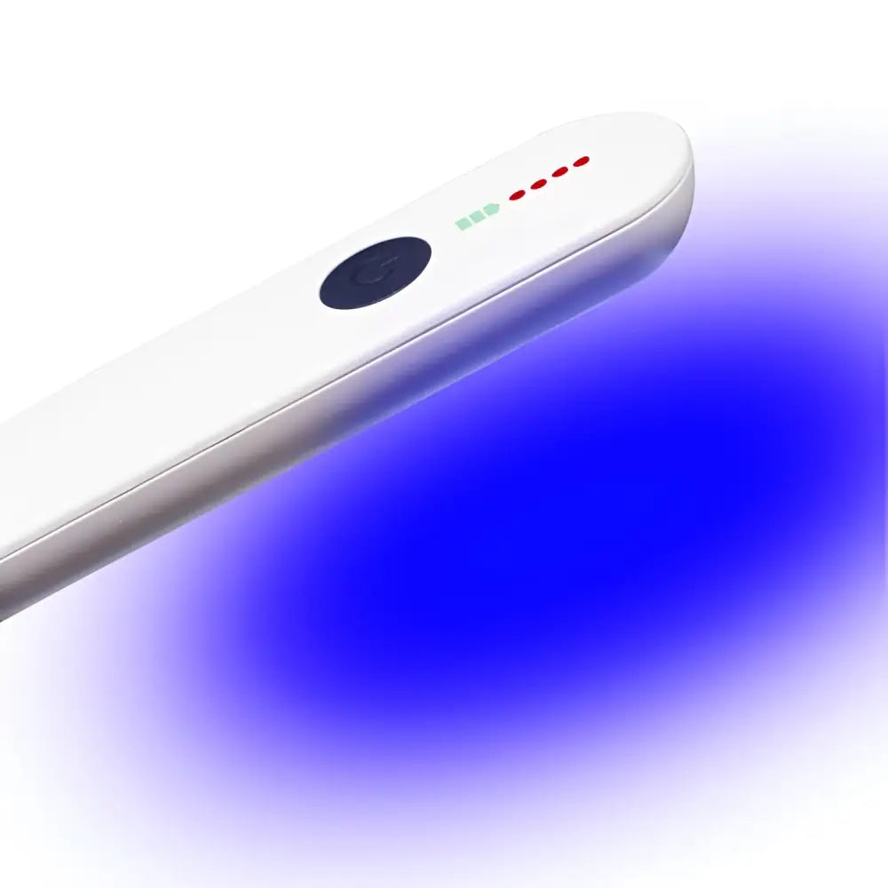 White handheld uv light with a black power button and led indicators emitting a blue glow.