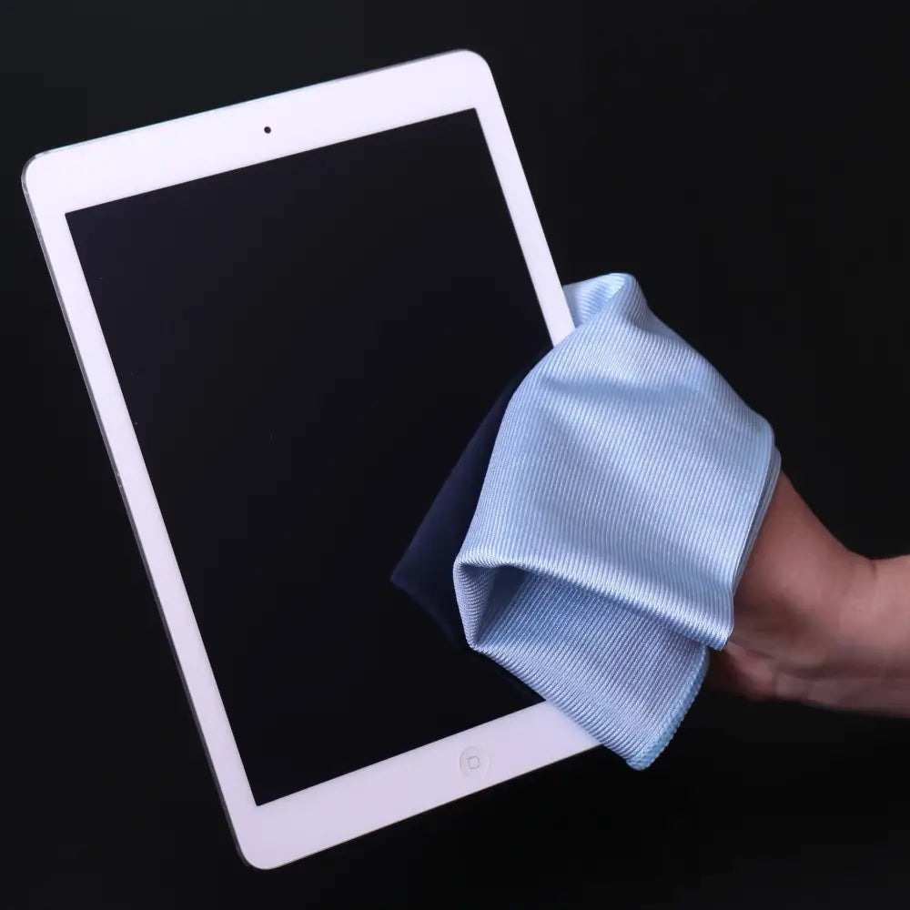 White ipad with a light blue microfiber cloth being used to wipe its screen.