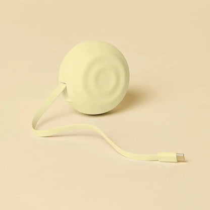 A soft, pale green circular portable charger with a smooth matte finish and concentric ridges on its surface.