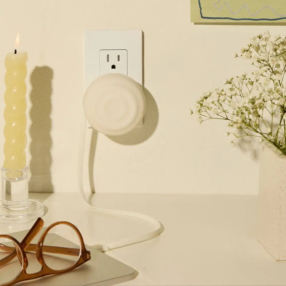 White circular plug-in night light with a soft glow.